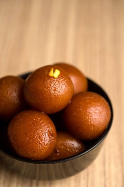 Hint Tatlısı ya da Tatlı Tabak: Ahşap arka planda Gulab Jamun.