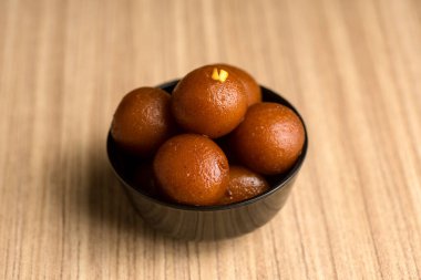 Hint Tatlısı ya da Tatlı Tabak: Ahşap arka planda Gulab Jamun.