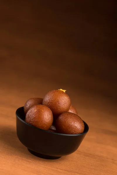 Indisches Dessert oder süßes Gericht: Gulab Jamun in Schale auf Holzgrund. — Stockfoto