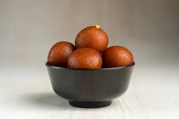 Indický dezert nebo sladké jídlo: Gulab Jamun v misce na dřevěném pozadí. — Stock fotografie