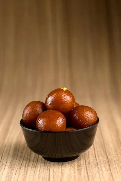 Indisches Dessert oder süßes Gericht: Gulab Jamun in Schale auf Holzgrund. — Stockfoto