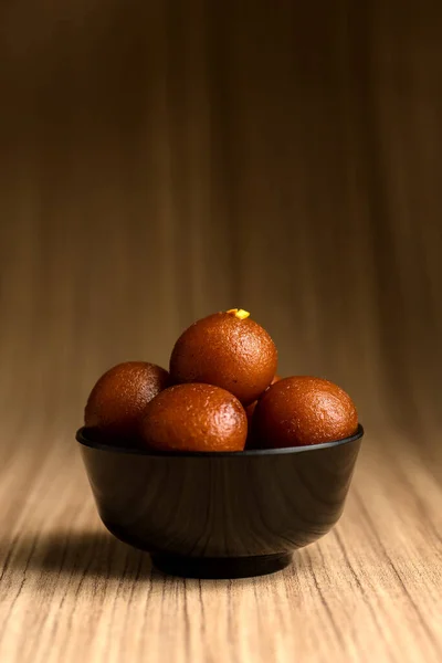 Indisches Dessert oder süßes Gericht: Gulab Jamun in Schale auf Holzgrund. — Stockfoto