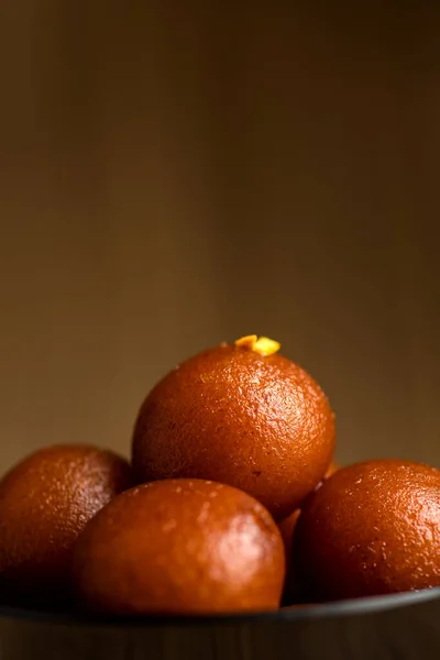 Indisches Dessert oder süßes Gericht: Gulab Jamun in Schale auf Holzgrund. — Stockfoto