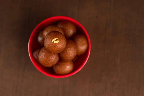 Gulab Jamun em tigela vermelha sobre fundo de madeira. Sobremesa indiana ou prato doce . — Fotografia de Stock