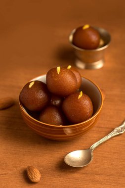 Kavanozda Jamun, kaşıkta bakır antika kâse. Hint Tatlısı ya da Tatlı Tabak.