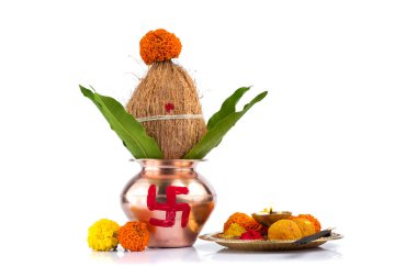 Hindistan cevizi ve mango yaprağıyla bakır Kalaş ve beyaz arka planda çiçek desenli diya, kumkum ve tatlılar ile pooja thali. Hindu pujası için gerekli..
