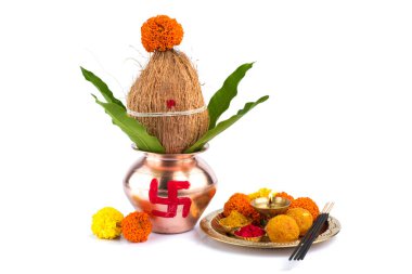 Hindistan cevizi ve mango yaprağıyla bakır Kalaş ve beyaz arka planda çiçek desenli diya, kumkum ve tatlılar ile pooja thali. Hindu pujası için gerekli..