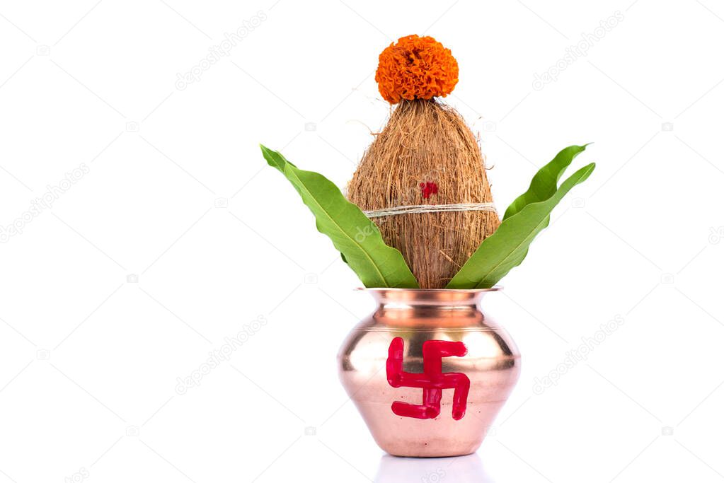 Copper Kalash with coconut and mango leaf with floral decoration on a white background. Essential in Hindu Puja.