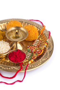 Hint Festivali: Rakhi, pirinç taneleri, kumkum, tatlılar ve şık bir Rakhi tabağında diya. Geleneksel Hint bilekliği Kardeşler ve Kız Kardeşler arasındaki aşkın sembolüdür.