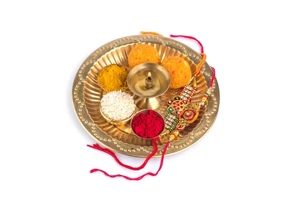 Індійський фестиваль: Ракі з рисовими зернами, кумкумом, солодощами і дья на тарілці з елегантним ракі. Традиційний індійський зап'ясток, який є символом любові між братами і сестрами. — стокове фото