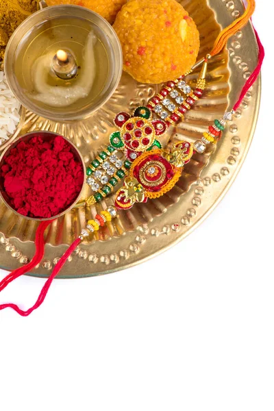 เทศกาลอินเดีย: Rakhi กับข้าวธัญพืช, คุมกุม, ขนมหวานและ diya บนจานกับ Rakhi หรูหรา วงข้อมืออินเดียแบบดั้งเดิมซึ่งเป็นสัญลักษณ์ของความรักระหว่างพี่น้องและพี่น้อง — ภาพถ่ายสต็อก