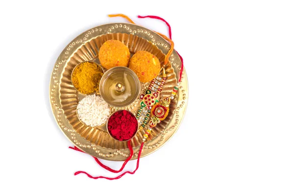 Indian Festival: Rakhi med riskorn, kumkum, godis och diya på tallrik med en elegant Rakhi. Ett traditionellt indiskt armband som är en symbol för kärlek mellan bröder och systrar — Stockfoto