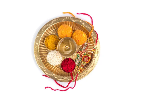 Indian Festival: Rakhi med riskorn, kumkum, godis och diya på tallrik med en elegant Rakhi. Ett traditionellt indiskt armband som är en symbol för kärlek mellan bröder och systrar — Stockfoto