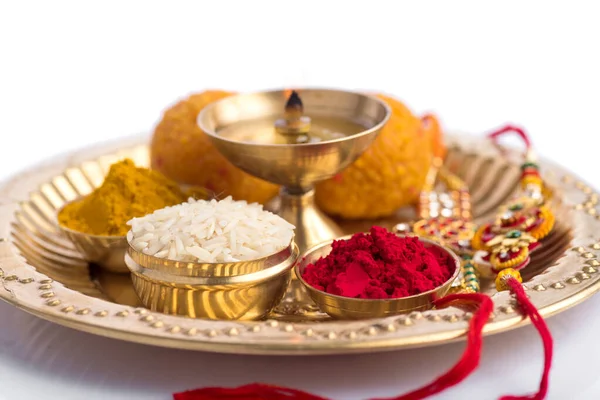 Festival Indio: Rakhi con granos de arroz, kumkum, dulces y diya en plato con un elegante Rakhi. Una pulsera india tradicional que es un símbolo de amor entre hermanos y hermanas — Foto de Stock