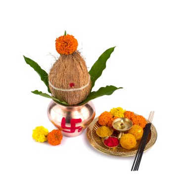 Hindistan cevizi ve mango yaprağıyla bakır Kalaş ve beyaz arka planda çiçek desenli diya, kumkum ve tatlılar ile pooja thali. Hindu pujası için gerekli..
