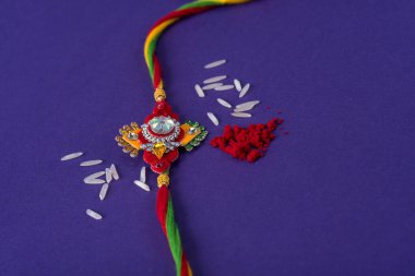 Raksha Bandhan: Pirinç ve kumkum taneli Rakhi. Hint şenliği geçmişi. Geleneksel Hint bilekliği Kardeşler ve Kız Kardeşler arasındaki aşkın sembolüdür..