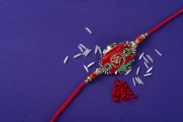 Raksha Bandhan : Rakhi with rice grains and kumkum. An Indian festive background. Traditional Indian wrist band which is a symbol of love between Brothers and Sisters.