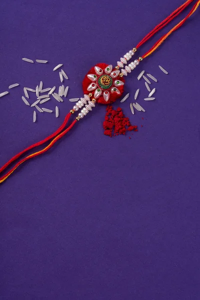 Raksha Bandhan : Rakhi with rice grains and kumkum. An Indian festive background. Traditional Indian wrist band which is a symbol of love between Brothers and Sisters.