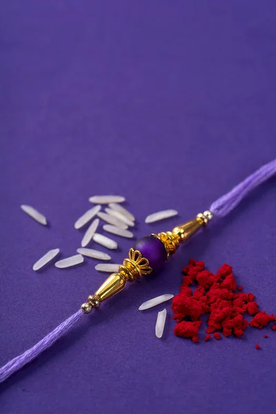 Raksha Bandhan : Rakhi with rice grains and kumkum. An Indian festive background. Traditional Indian wrist band which is a symbol of love between Brothers and Sisters.