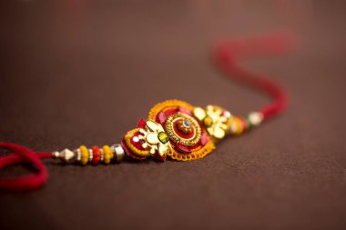 Raksha Bandhan 'ın arkaplanı zarif bir Rakhi. Geleneksel Hint bilekliği Kardeşler ve Kız Kardeşler arasındaki aşkın sembolüdür..