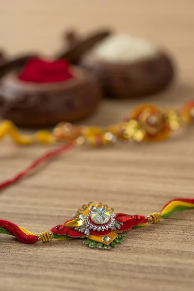 Indian festival: Raksha Bandhan background with an elegant Rakhi, Rice Grains and Kumkum. A traditional Indian wrist band which is a symbol of love between Brothers and Sisters.