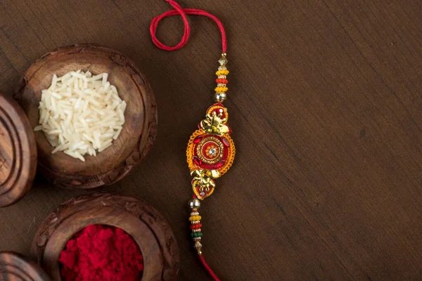 Hint festivali: Raksha Bandhan özgeçmişi zarif bir Rakhi, pirinç taneleri ve Kumkum ile. Geleneksel Hint bilekliği Kardeşler ve Kız Kardeşler arasındaki aşkın sembolüdür..