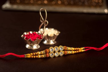 Hint festivali: Raksha Bandhan özgeçmişi zarif bir Rakhi, pirinç taneleri ve Kumkum ile. Geleneksel Hint bilekliği Kardeşler ve Kız Kardeşler arasındaki aşkın sembolüdür..