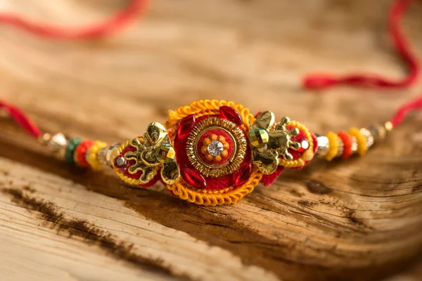 Indiska festival: Raksha Bandhan bakgrund med en elegant Rakhi, Rice Grains och Kumkum. Ett traditionellt indiskt armband som är en symbol för kärlek mellan bröder och systrar. — Stockfoto