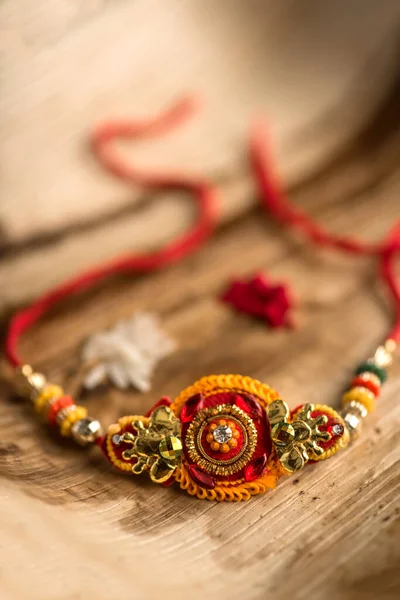 Indisk festival: Raksha Bandhan baggrund med en elegant Rakhi, Ris korn og Kumkum. En traditionel indisk armbånd, som er et symbol på kærlighed mellem brødre og søstre. - Stock-foto