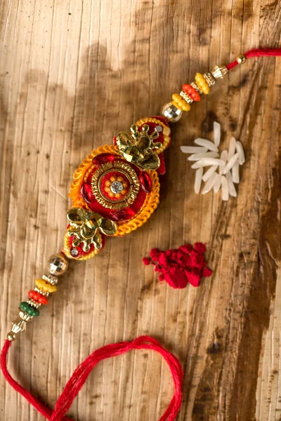Hint festivali: Raksha Bandhan özgeçmişi zarif bir Rakhi, pirinç taneleri ve Kumkum ile. Geleneksel Hint bilekliği Kardeşler ve Kız Kardeşler arasındaki aşkın sembolüdür.. — Stok fotoğraf