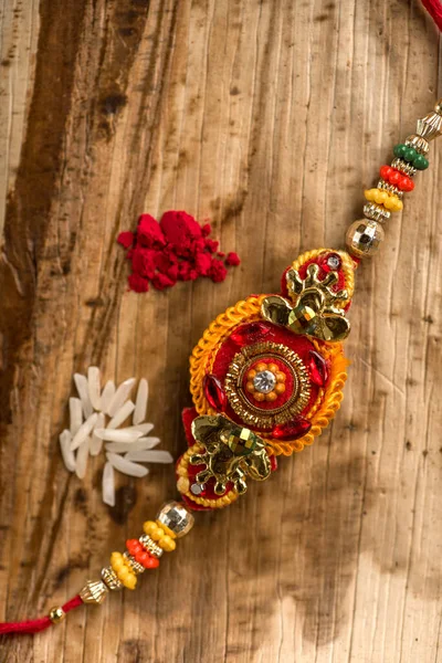 Indisk festival: Raksha Bandhan baggrund med en elegant Rakhi, Ris korn og Kumkum. En traditionel indisk armbånd, som er et symbol på kærlighed mellem brødre og søstre. - Stock-foto