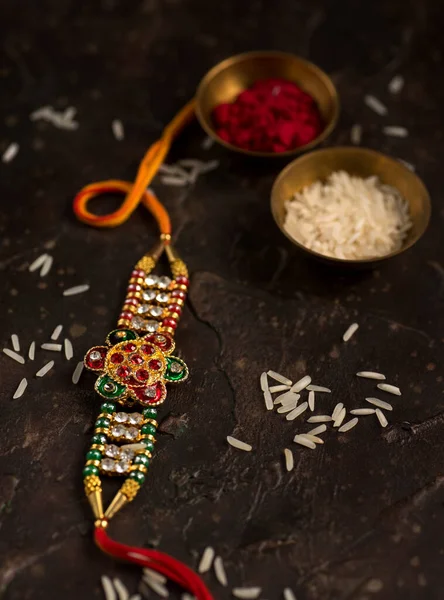 Raksha Bandhan тло з елегантним Rakhi, Rice Grains і Kumkum. Традиційний індійський зап'ясток, який є символом любові між братами і сестрами.. — стокове фото