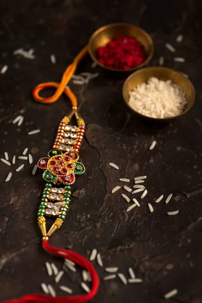 Raksha Bandhan тло з елегантним Rakhi, Rice Grains і Kumkum. Традиційний індійський зап'ясток, який є символом любові між братами і сестрами.. — стокове фото