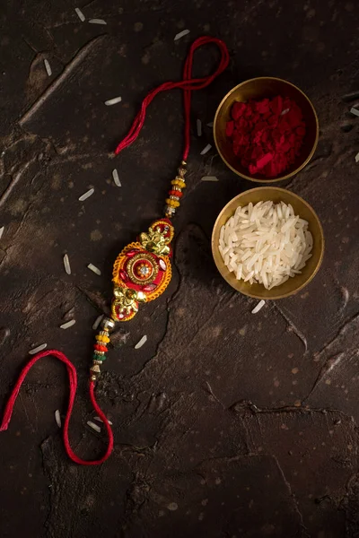 Raksha Bandhan fundo com um elegante Rakhi, grãos de arroz e Kumkum. Uma pulseira tradicional indiana que é um símbolo de amor entre irmãos e irmãs . — Fotografia de Stock