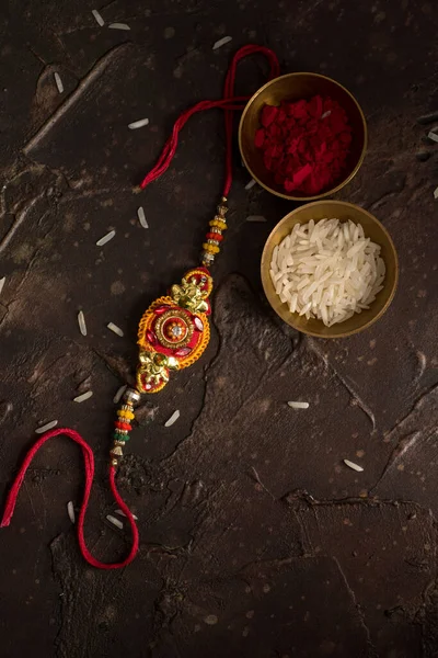 Raksha Bandhan fundo com um elegante Rakhi, grãos de arroz e Kumkum. Uma pulseira tradicional indiana que é um símbolo de amor entre irmãos e irmãs . — Fotografia de Stock