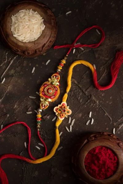 Raksha Bandhan тло з елегантним Rakhi, Rice Grains і Kumkum. Традиційний індійський зап'ясток, який є символом любові між братами і сестрами.. — стокове фото