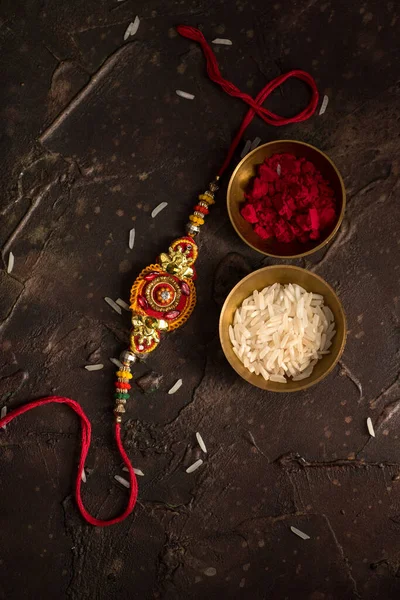 Raksha Bandhan 'ın arkaplanı zarif bir Rakhi, pirinç taneleri ve Kumkum. Geleneksel Hint bilekliği Kardeşler ve Kız Kardeşler arasındaki aşkın sembolüdür.. — Stok fotoğraf