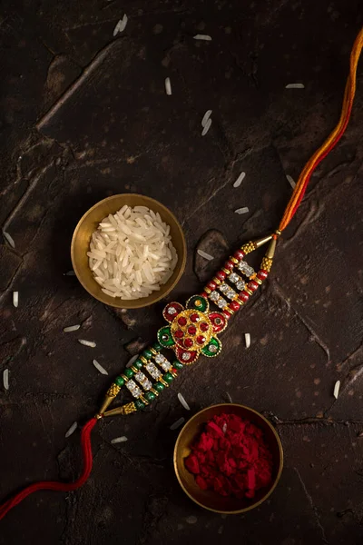 Raksha Bandhan тло з елегантним Rakhi, Rice Grains і Kumkum. Традиційний індійський зап'ясток, який є символом любові між братами і сестрами.. — стокове фото