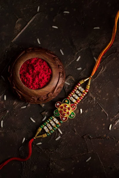 Raksha Bandhan fundo com um elegante Rakhi, grãos de arroz e Kumkum. Uma pulseira tradicional indiana que é um símbolo de amor entre irmãos e irmãs . — Fotografia de Stock