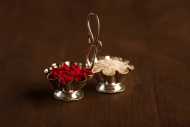 Kumkum ve pirinç tanecikleri. Doğal renk tozları, Tanrı 'ya ibadet ederken ve hayırlı durumlarda kullanılır..