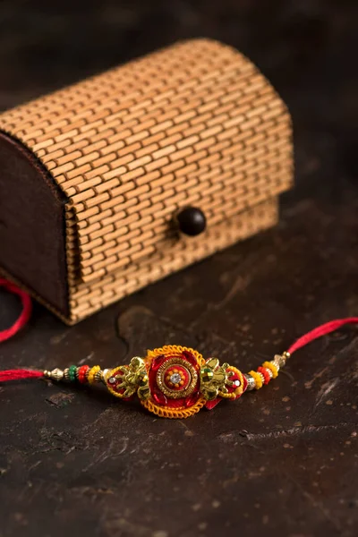 Raksha Bandhan bakgrund med en elegant Rakhi, riskorn, Kumkum och presentförpackning. Ett traditionellt indiskt armband som är en symbol för kärlek mellan bröder och systrar. — Stockfoto