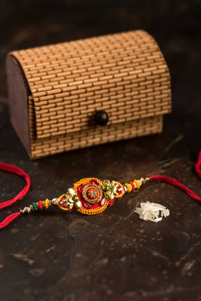 Raksha Bandhan тло з елегантним Rakhi, Rice Grains, Kumkum і подарунковим ящиком. Традиційний індійський зап'ясток, який є символом любові між братами і сестрами.. — стокове фото