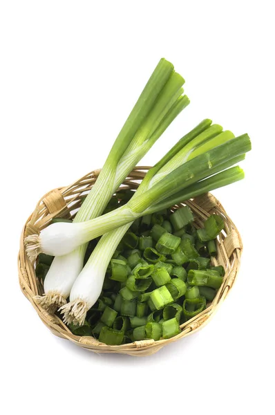 Свежий зеленый лук (лук-шалот или скалот) с нарезанным луком в корзине на белом фоне — стоковое фото