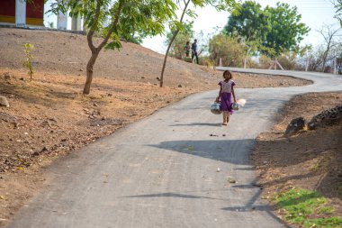 Amravati, Maharashtra, Hindistan - 17 Haziran 2017: Bir kuyudan içme suyu toplamak için köyden gelen kimliği belirsiz kız.