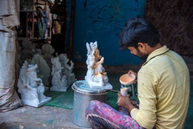 Amravati, Maharashtra - 25 Ağustos 2018: Sanatçı bir heykel yapıyor ve Ganesha festivali için bir sanatçı atölyesinde Hindu tanrısı Lord Ganesha 'nın bir putuna son rötuşlarını yapıyor.