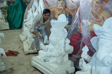 Amravati, Maharashtra - 8 Eylül 2018: Sanatçı bir heykel yapıyor ve Ganesha festivali için bir sanatçı atölyesinde Hindu tanrısı Lord Ganesha 'nın bir putuna son rötuşlarını yapıyor.