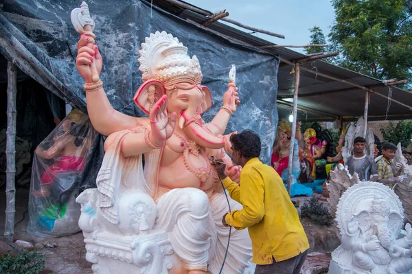 AMRAVATI, MAHARASHTRA - 8 DE SEPTIEMBRE DE 2018: Artista haciendo una estatua y dando toques finales a un ídolo del dios hindú Lord Ganesha en un taller de artista para el festival Ganesha . — Foto de Stock