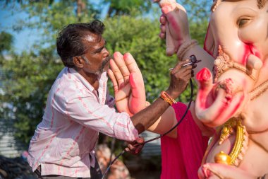 Amravati, Maharashtra - 8 Eylül 2018: Sanatçı bir heykel yapıyor ve Ganesha festivali için bir sanatçı atölyesinde Hindu tanrısı Lord Ganesha 'nın bir putuna son rötuşlarını yapıyor.