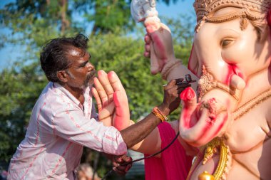 Amravati, Maharashtra - 8 Eylül 2018: Sanatçı bir heykel yapıyor ve Ganesha festivali için bir sanatçı atölyesinde Hindu tanrısı Lord Ganesha 'nın bir putuna son rötuşlarını yapıyor.