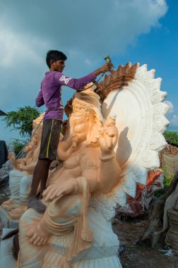 Amravati, Maharashtra - 8 Eylül 2018: Sanatçı bir heykel yapıyor ve Ganesha festivali için bir sanatçı atölyesinde Hindu tanrısı Lord Ganesha 'nın bir putuna son rötuşlarını yapıyor.